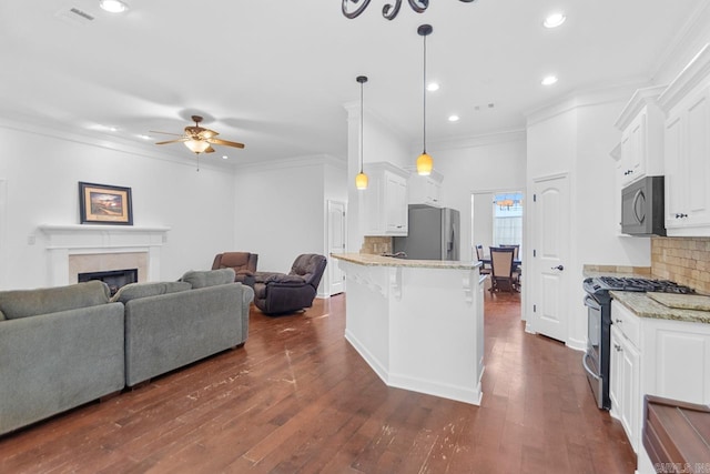 kitchen featuring dark wood-type flooring, hanging light fixtures, stainless steel appliances, light stone counters, and white cabinets