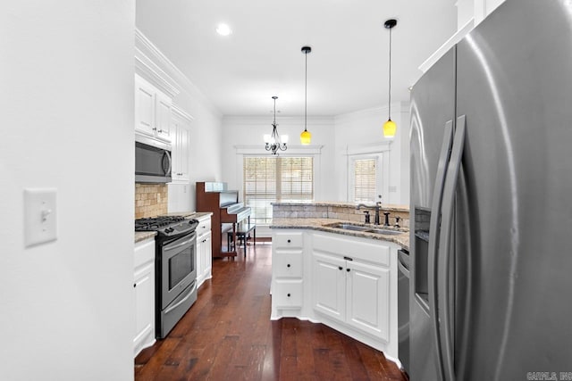 kitchen featuring dark wood-type flooring, pendant lighting, stone countertops, white cabinets, and appliances with stainless steel finishes