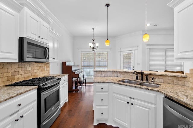 kitchen featuring appliances with stainless steel finishes, sink, pendant lighting, dark hardwood / wood-style floors, and white cabinetry