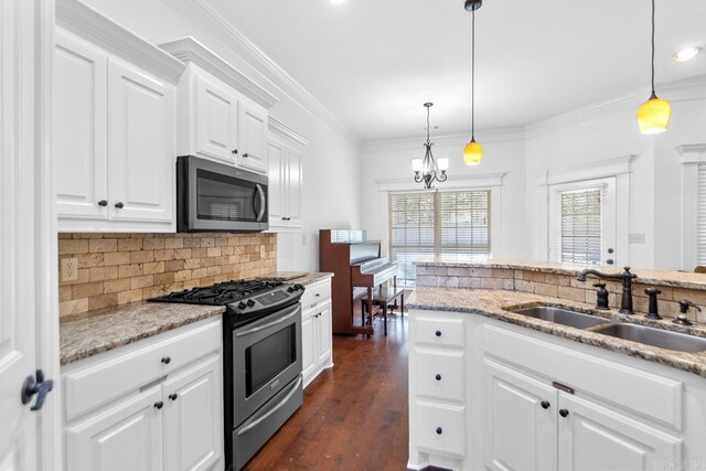 kitchen featuring hanging light fixtures, white cabinetry, sink, and appliances with stainless steel finishes