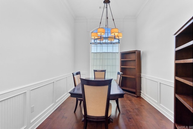 dining area featuring dark hardwood / wood-style flooring, ornamental molding, and a chandelier