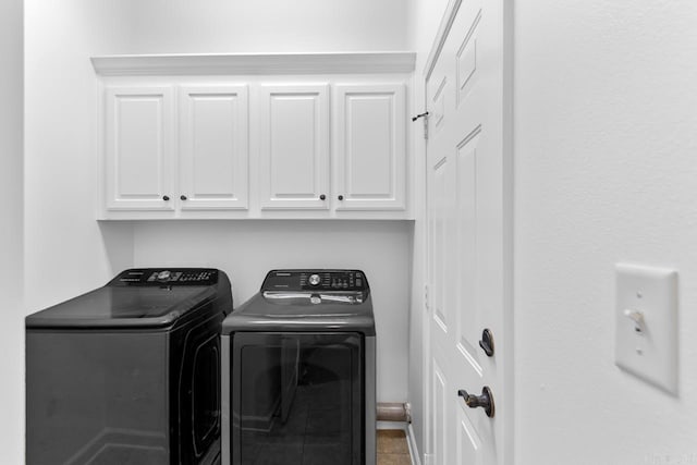 washroom featuring tile patterned floors, washer and clothes dryer, and cabinets