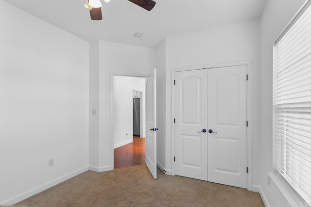 unfurnished bedroom featuring carpet flooring, ceiling fan, and a closet