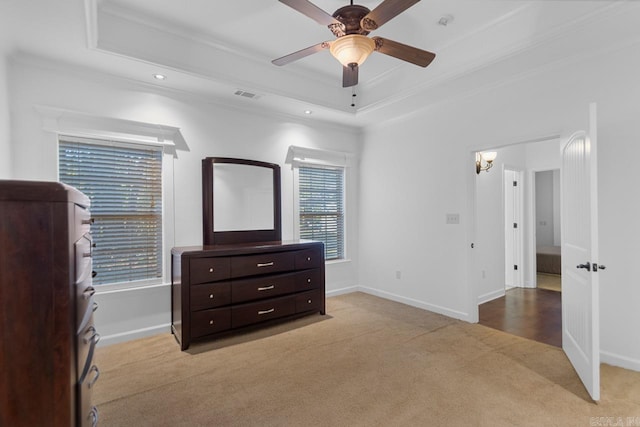 carpeted bedroom featuring ceiling fan, a raised ceiling, and ornamental molding