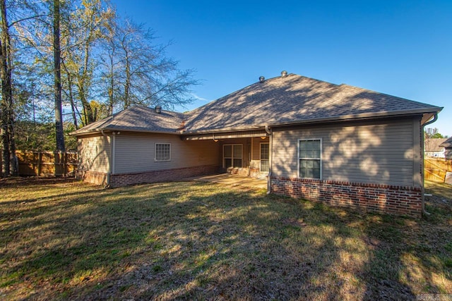 rear view of property featuring a yard