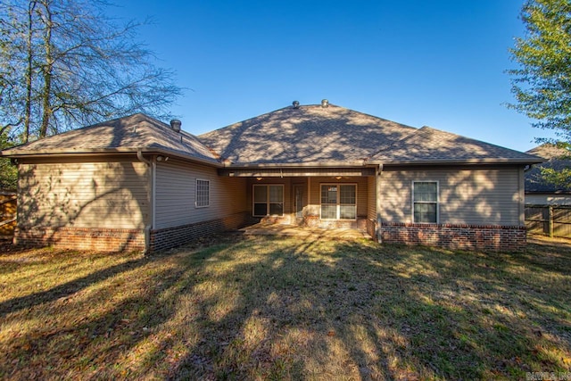 back of property featuring a lawn