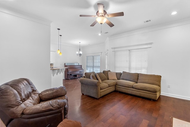 living room with dark wood-type flooring, ceiling fan with notable chandelier, and ornamental molding