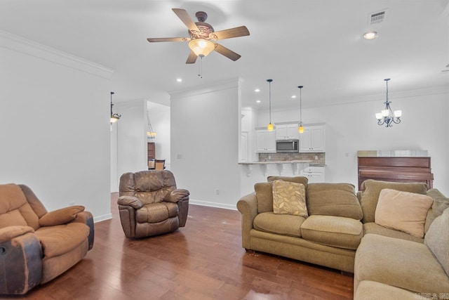 living room featuring ceiling fan with notable chandelier, crown molding, and dark wood-type flooring