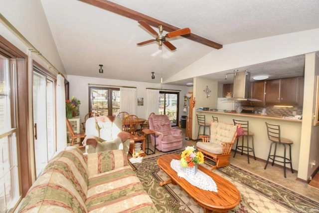 living room featuring a textured ceiling, lofted ceiling with beams, and ceiling fan