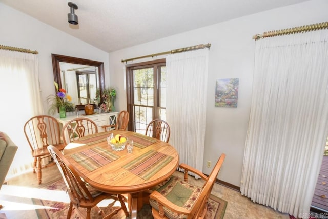 carpeted dining room featuring lofted ceiling