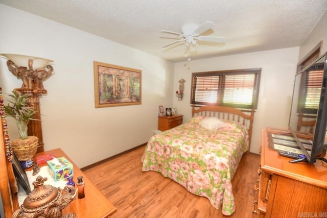 bedroom with a textured ceiling, light wood-type flooring, and ceiling fan