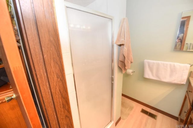 bathroom featuring hardwood / wood-style floors, vanity, and walk in shower