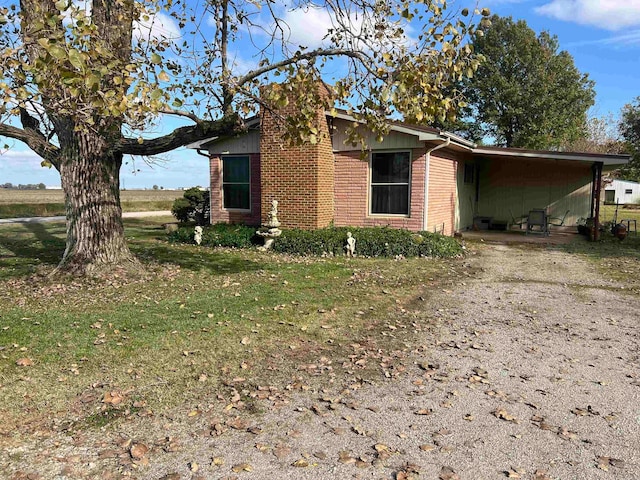 view of home's exterior featuring a lawn and a carport