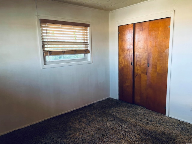 unfurnished bedroom featuring carpet flooring, a closet, and crown molding