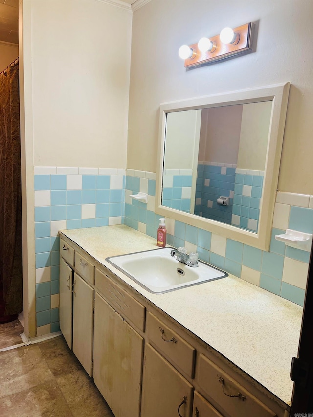 bathroom featuring vanity, ornamental molding, and tile walls