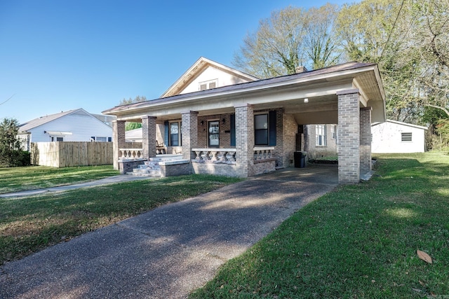 view of front of property featuring a carport, a porch, and a front lawn