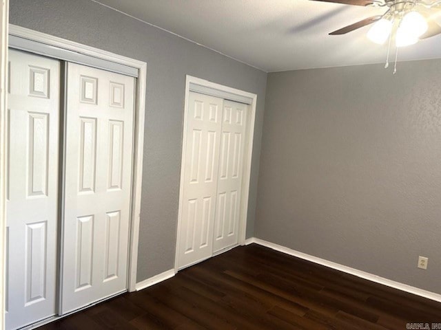 unfurnished bedroom with ceiling fan and dark hardwood / wood-style flooring