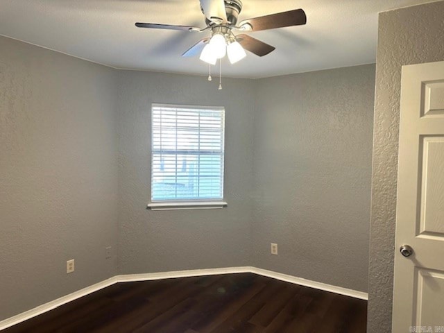 unfurnished room with dark hardwood / wood-style floors and ceiling fan