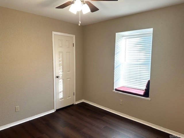 unfurnished room featuring dark hardwood / wood-style flooring, ceiling fan, and plenty of natural light