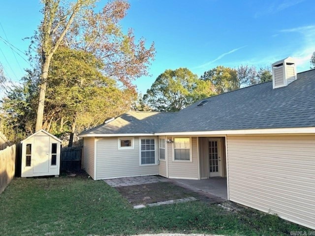 back of house featuring a lawn, a storage unit, and a patio