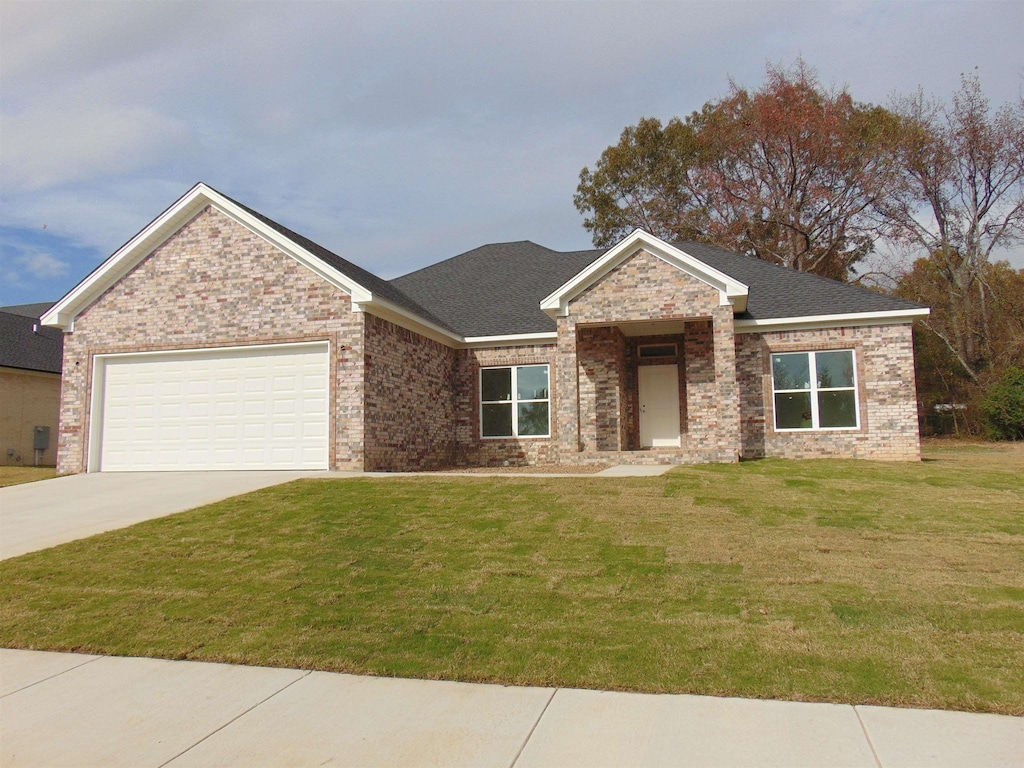 view of front of property with a garage and a front lawn