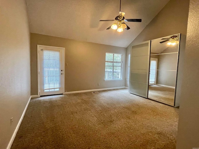 unfurnished bedroom with ceiling fan, carpet floors, a textured ceiling, and high vaulted ceiling