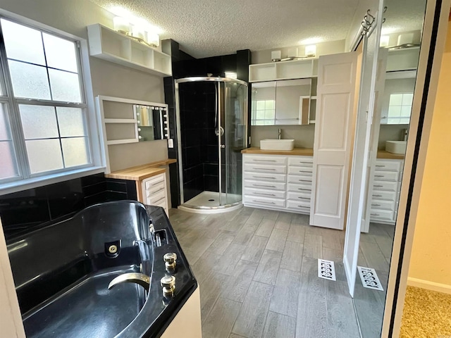 bathroom featuring plenty of natural light, wood-type flooring, a textured ceiling, and shower with separate bathtub