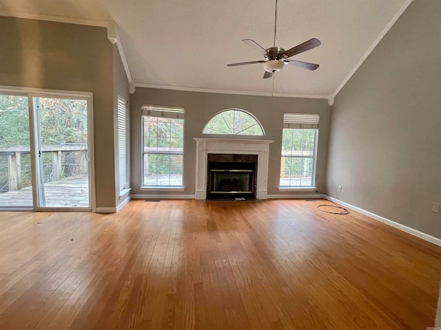 unfurnished living room with light wood-type flooring, high vaulted ceiling, ceiling fan, and ornamental molding