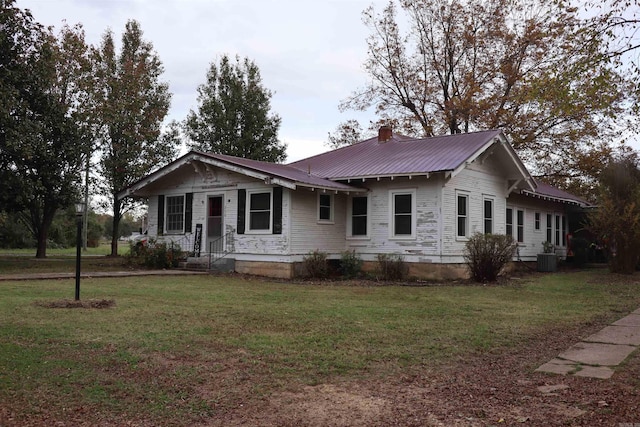 view of front of house featuring central AC unit and a front lawn