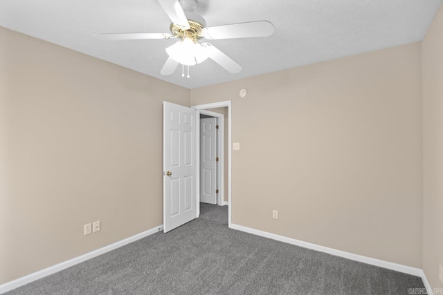 unfurnished room with ceiling fan and carpet