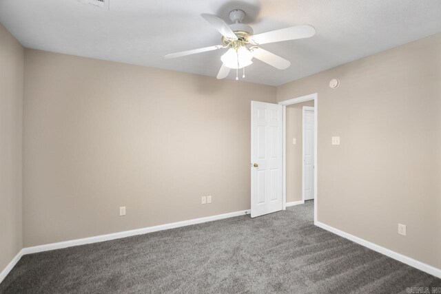 empty room with ceiling fan and dark carpet