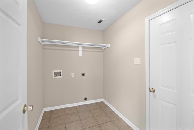 washroom with hookup for an electric dryer, light tile patterned floors, a textured ceiling, and washer hookup