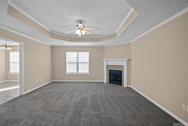 unfurnished living room featuring a tray ceiling, carpet flooring, and ornamental molding