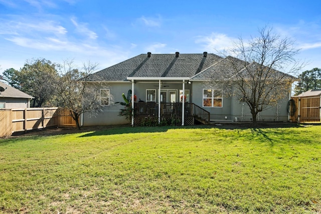 back of house with a lawn and ceiling fan