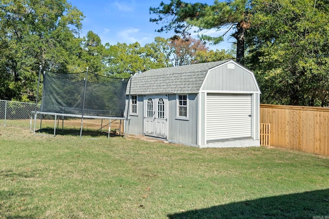 view of outdoor structure with a lawn and a trampoline