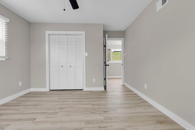 unfurnished bedroom with ceiling fan, a closet, and light hardwood / wood-style floors