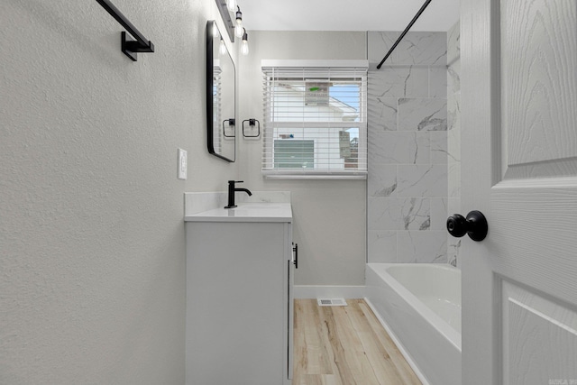 bathroom with vanity, tiled shower / bath combo, and hardwood / wood-style flooring