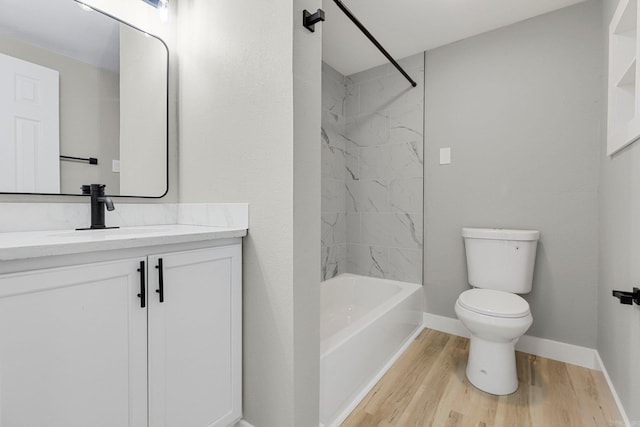 full bathroom featuring vanity, hardwood / wood-style flooring, toilet, and tiled shower / bath combo