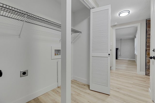 washroom with electric dryer hookup, hookup for a washing machine, and light hardwood / wood-style floors