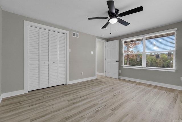 unfurnished bedroom featuring ceiling fan, light hardwood / wood-style floors, and a closet