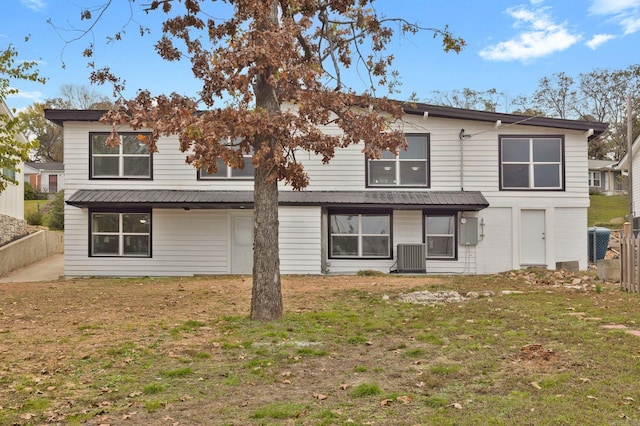 back of property featuring a lawn and cooling unit