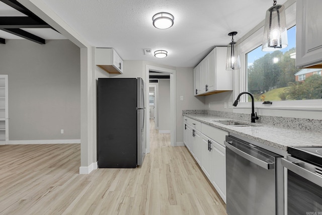 kitchen featuring white cabinetry, sink, light hardwood / wood-style floors, decorative light fixtures, and appliances with stainless steel finishes