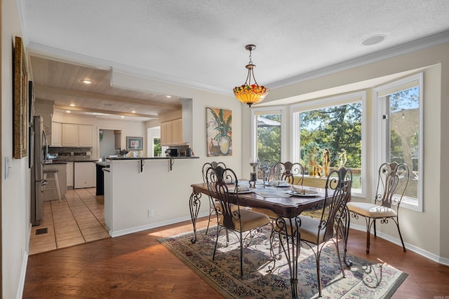 dining space with crown molding, wood ceiling, a textured ceiling, and hardwood / wood-style flooring