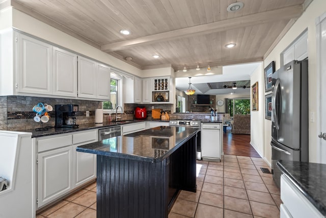 kitchen with kitchen peninsula, a kitchen island, white cabinetry, and stainless steel appliances