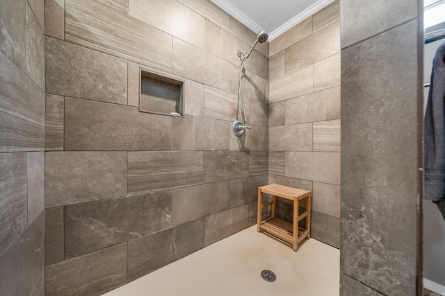 bathroom featuring ornamental molding and tiled shower