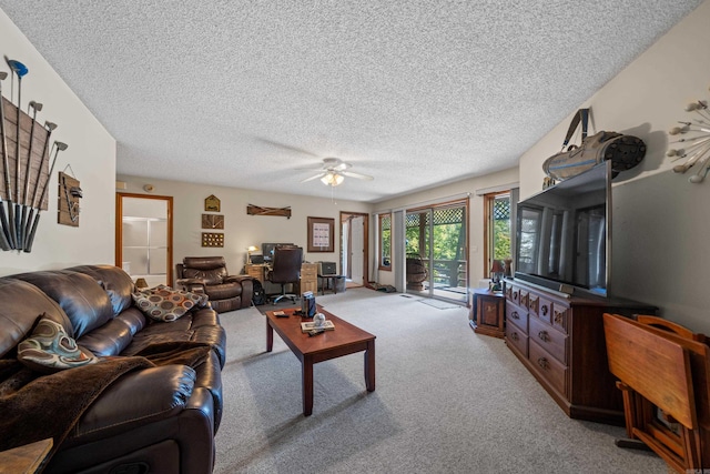 living room featuring ceiling fan, light carpet, and a textured ceiling