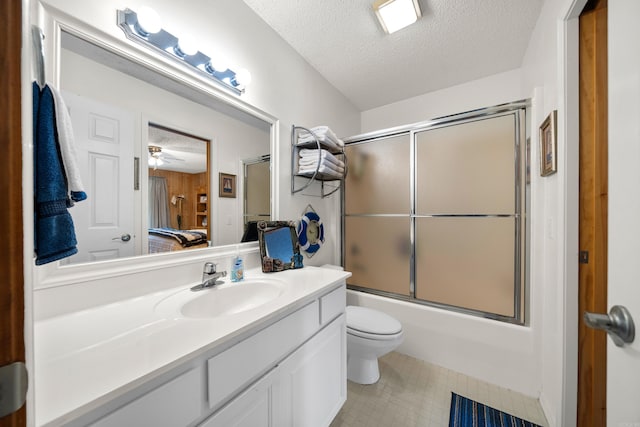 full bathroom with ceiling fan, combined bath / shower with glass door, a textured ceiling, toilet, and vanity