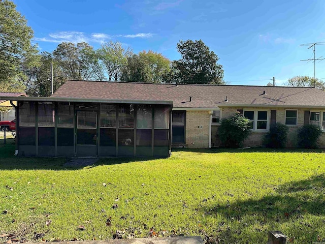 back of house with a yard and a sunroom