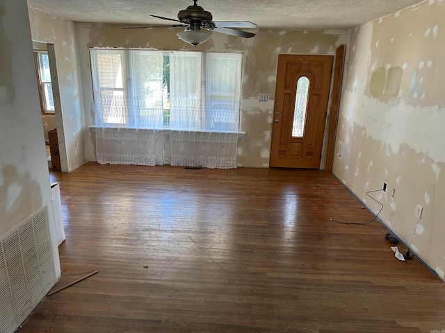 foyer with dark hardwood / wood-style floors, ceiling fan, and a textured ceiling