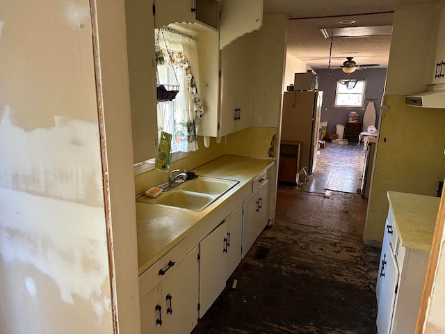 kitchen with sink, white cabinets, and a textured ceiling